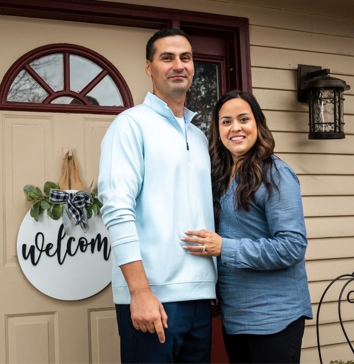 Couple standing outside of their house