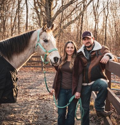 Young couple with a horse in a pasture