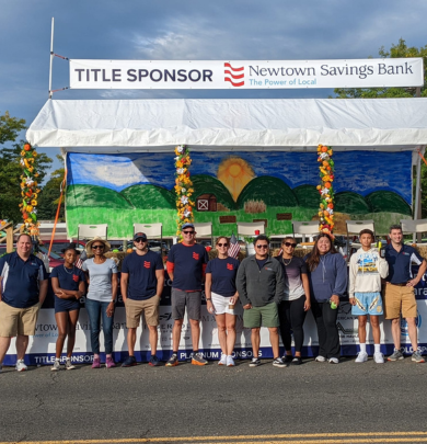 Group of employees in front of Newtown Labor Day Parade grandstand